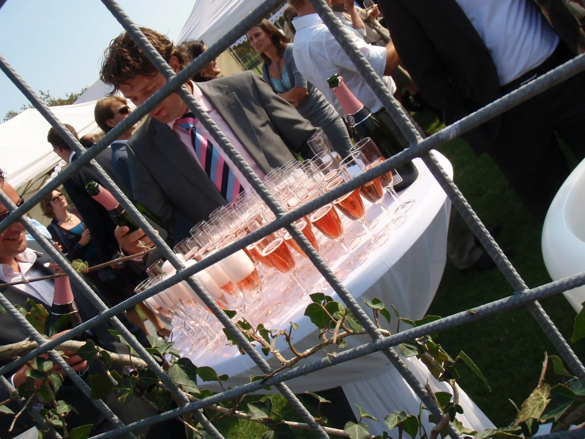 Champagneglazen worden ingeschonken tijdens een bruiloftsreceptie in de buitenlucht