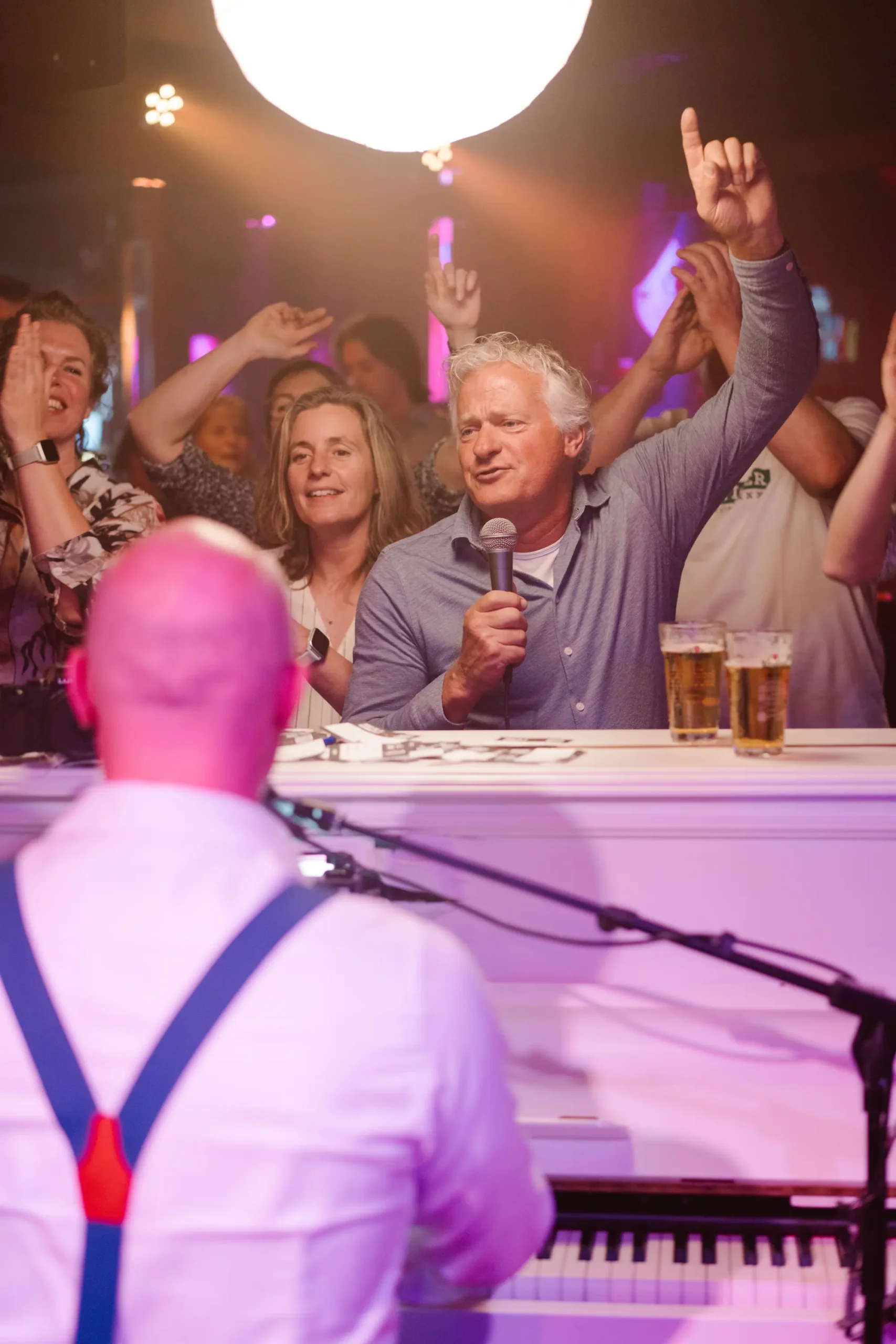 Live piano-entertainment waarbij een gast meezingt tijdens een sfeervol privéfeest