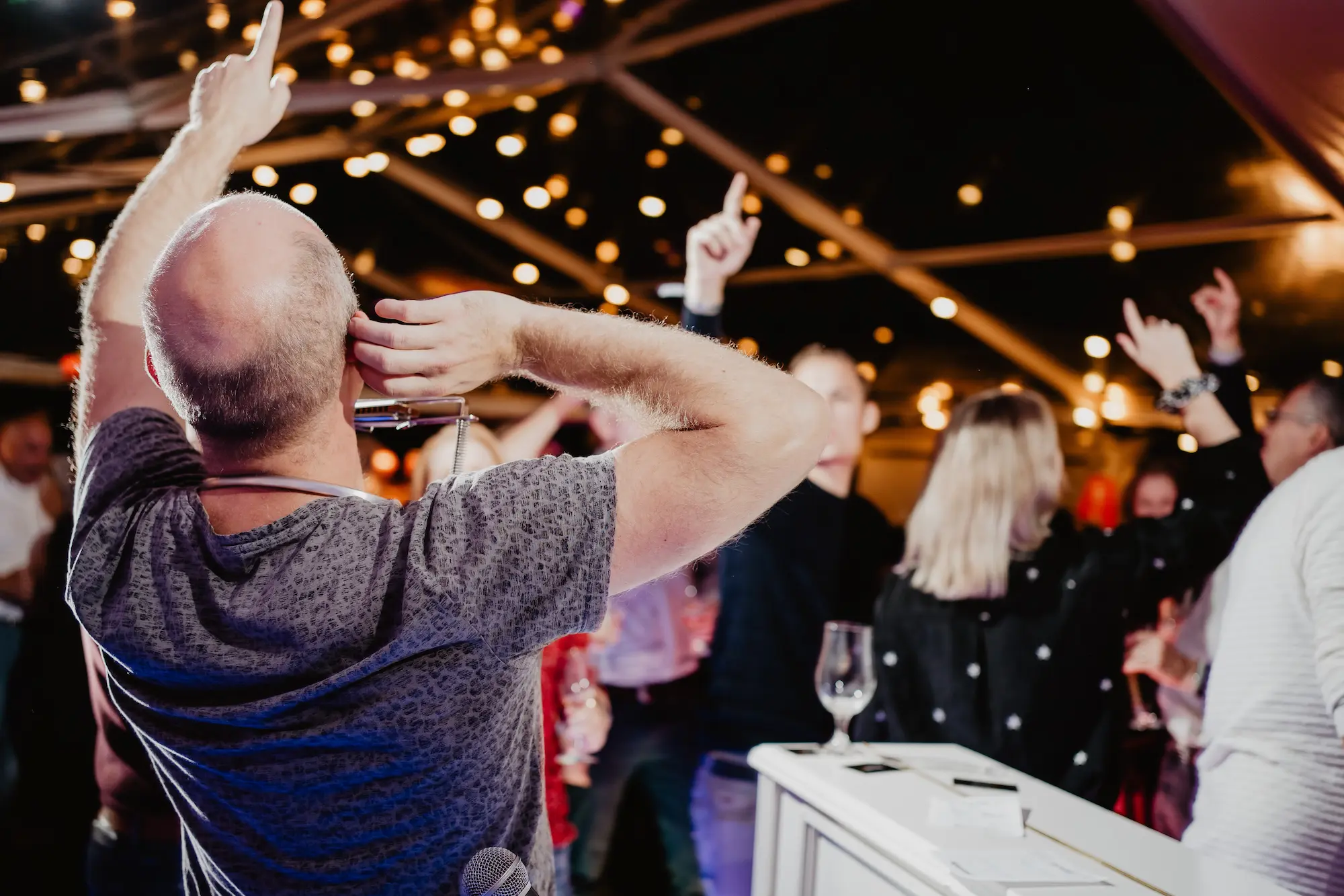 Publiek zingt en beweegt mee tijdens live piano-entertainment op een privéfeest