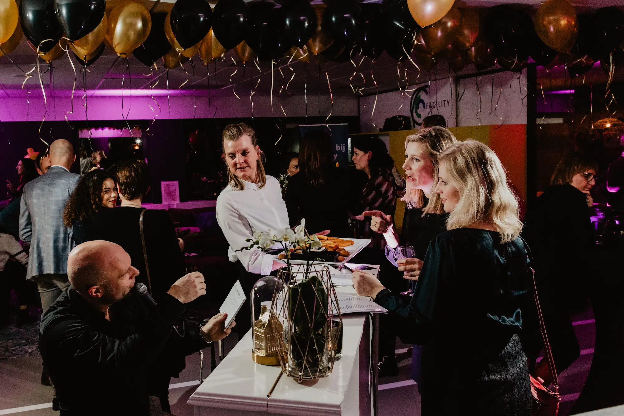 Pianist in gesprek met gasten tijdens een zakelijke netwerkborrel met live muziek