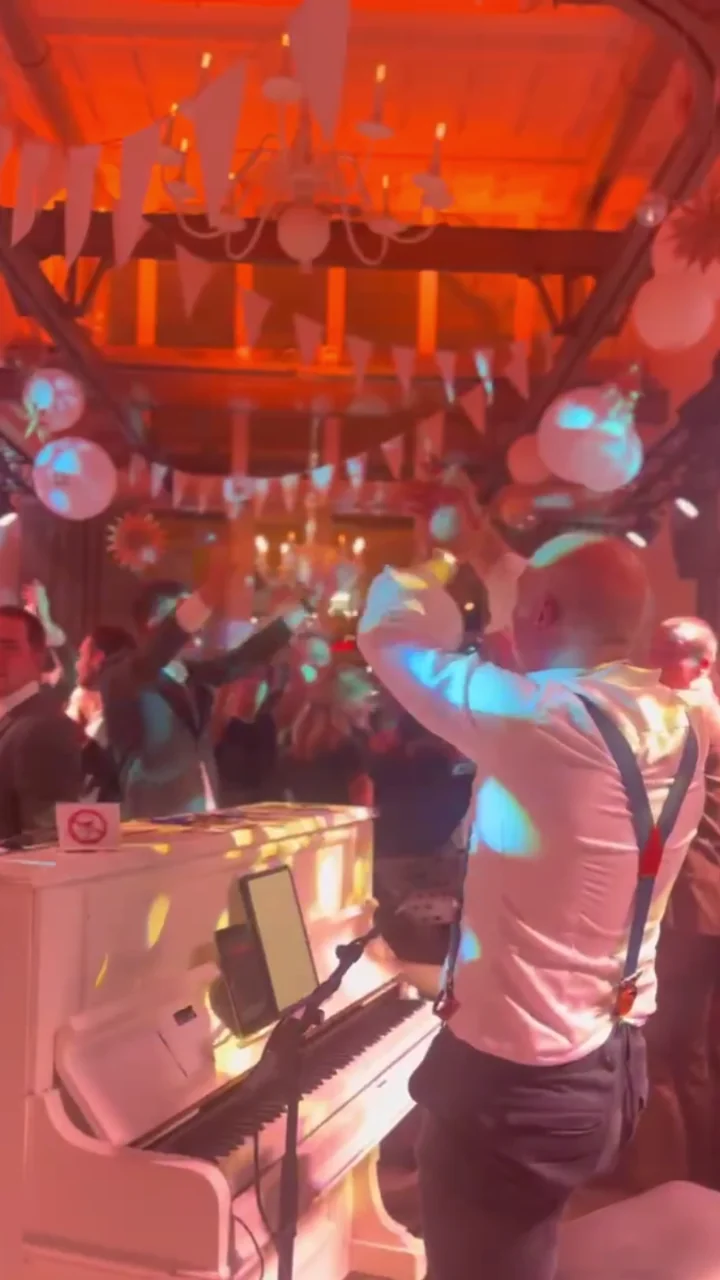 Publiek zingt en klapt mee terwijl De Pianoman Hey Jude speelt op een bruiloft